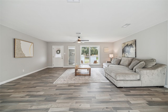 living room with a ceiling fan, wood finished floors, visible vents, and baseboards