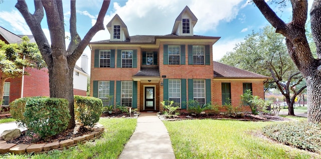 view of front of property featuring a front lawn and brick siding