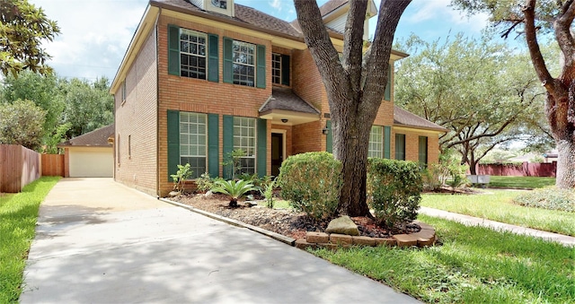 traditional-style home with a shingled roof, fence, and brick siding