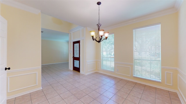 unfurnished room featuring a wainscoted wall, light tile patterned floors, a decorative wall, and an inviting chandelier