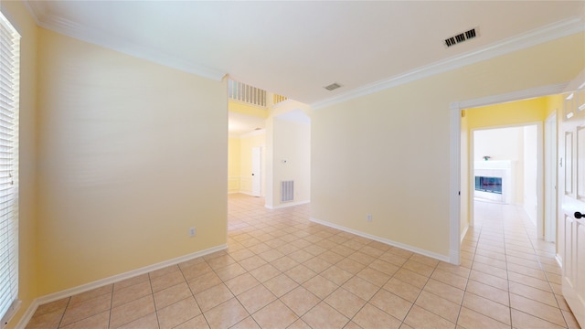 spare room featuring a fireplace, visible vents, and crown molding