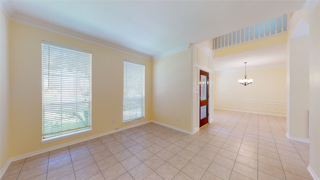 empty room featuring crown molding, a notable chandelier, a decorative wall, and light tile patterned floors