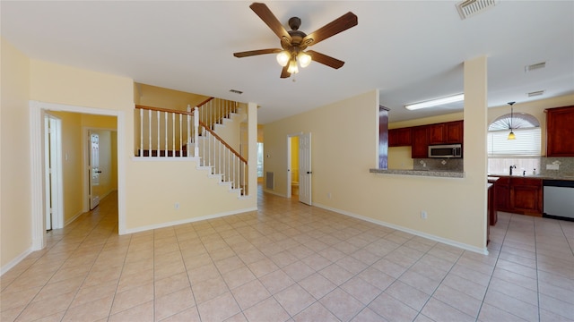 unfurnished living room with stairway, light tile patterned flooring, visible vents, and baseboards