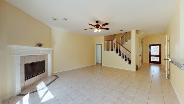 unfurnished living room featuring stairs, light tile patterned flooring, a fireplace, and visible vents