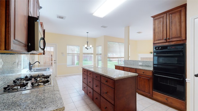 kitchen featuring dobule oven black, stainless steel gas cooktop, a sink, visible vents, and tasteful backsplash