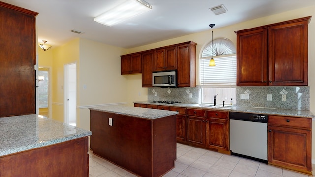 kitchen with stainless steel microwave, a sink, visible vents, and dishwashing machine