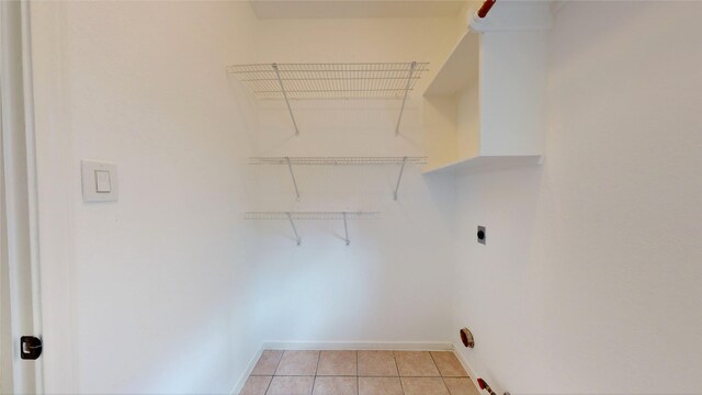 clothes washing area with baseboards, light tile patterned floors, and hookup for an electric dryer