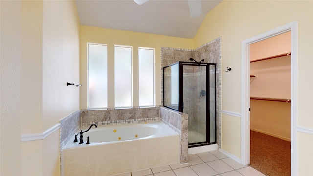 bathroom featuring a walk in closet, vaulted ceiling, a shower stall, a whirlpool tub, and tile patterned floors