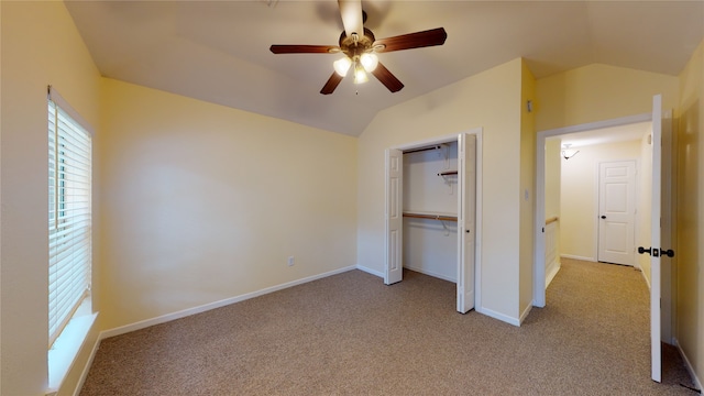 unfurnished bedroom with lofted ceiling, carpet floors, a closet, and baseboards