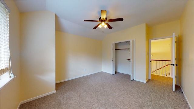 unfurnished bedroom featuring lofted ceiling, baseboards, and carpet floors