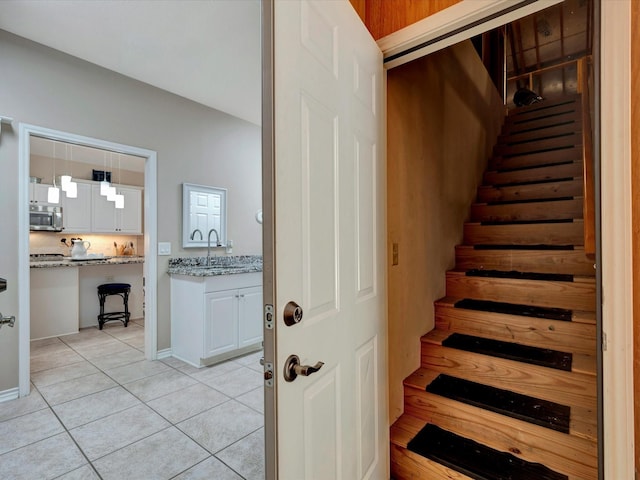 stairway featuring baseboards and tile patterned floors