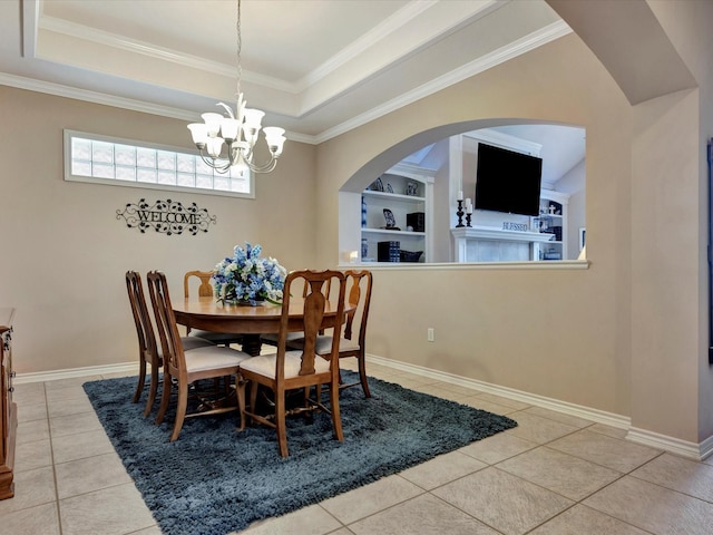 tiled dining space with baseboards, an inviting chandelier, a raised ceiling, and built in features