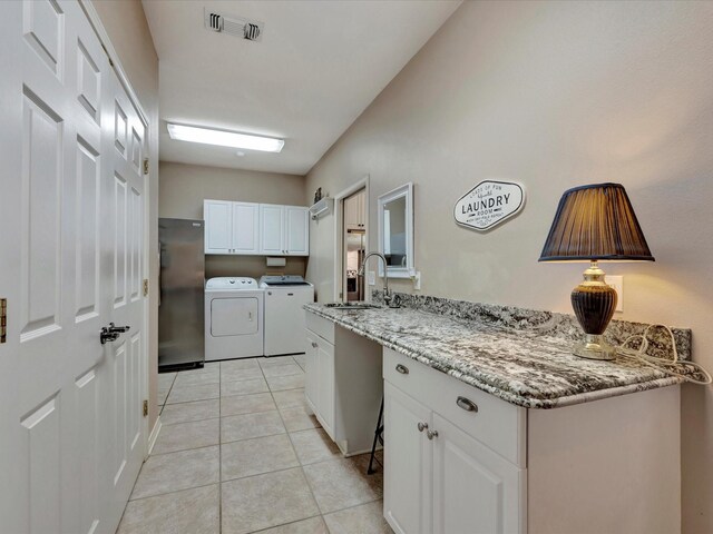 2601 Woodstock Dr, Lufkin, TX 75904 - laundry room featuring cabinet space, separate washer and dryer, and light tile patterned flooring