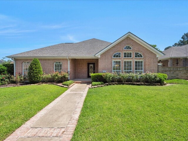 2601 Woodstock Dr, Lufkin, TX 75904 - view of front facade with brick siding, a front yard, and a shingled roof