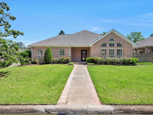 2601 Woodstock Dr, Lufkin, TX 75904 - view of front of home featuring brick siding and a front yard