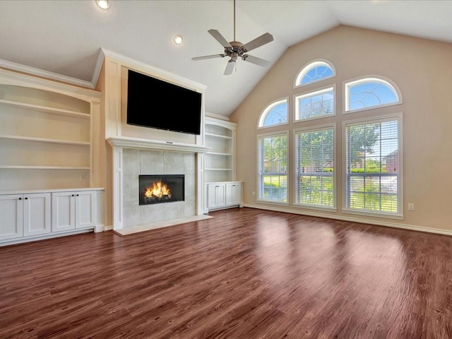 2601 Woodstock Dr, Lufkin, TX 75904 - unfurnished living room with ceiling fan, a tile fireplace, wood finished floors, vaulted ceiling, and built in shelves