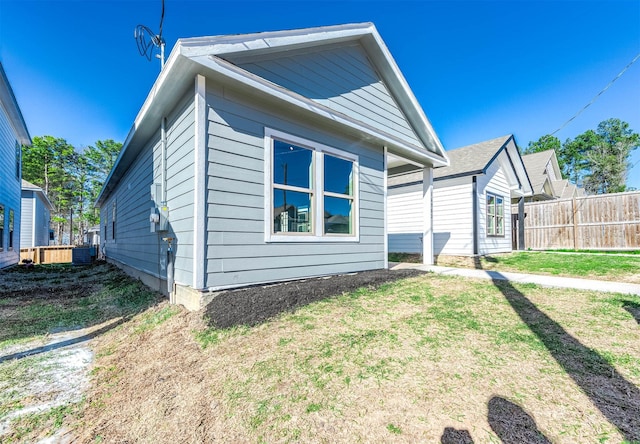 rear view of property with a yard and fence