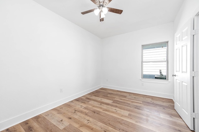 spare room featuring a ceiling fan, baseboards, and light wood finished floors