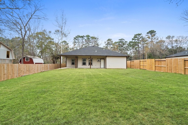 back of property featuring a yard and a fenced backyard