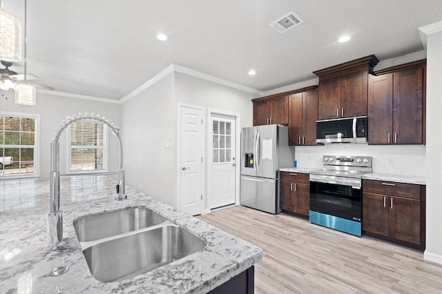 kitchen featuring light wood finished floors, visible vents, appliances with stainless steel finishes, a sink, and dark brown cabinets