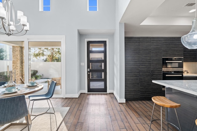 kitchen featuring dark wood-type flooring, a wealth of natural light, visible vents, and a breakfast bar area