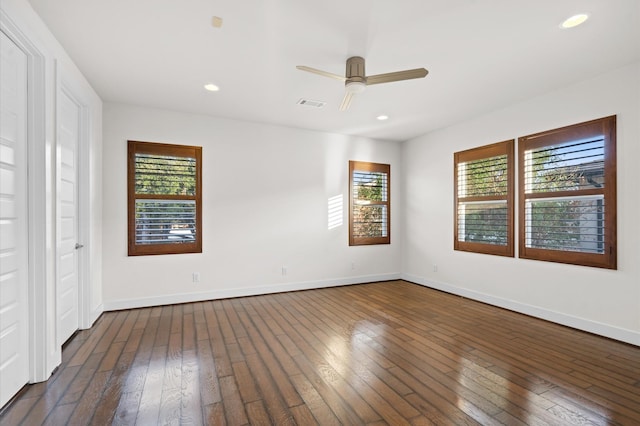 empty room featuring baseboards, visible vents, dark wood finished floors, and recessed lighting