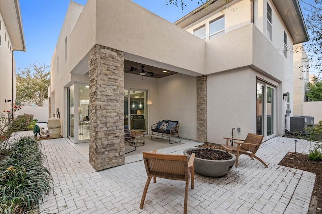 view of patio / terrace with cooling unit, ceiling fan, and a fire pit