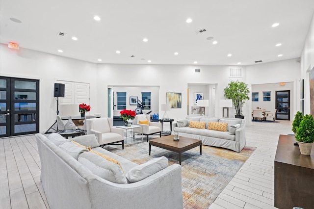 living room with light wood-type flooring, visible vents, and recessed lighting