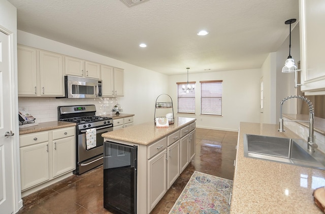 kitchen featuring decorative backsplash, wine cooler, decorative light fixtures, stainless steel appliances, and a sink