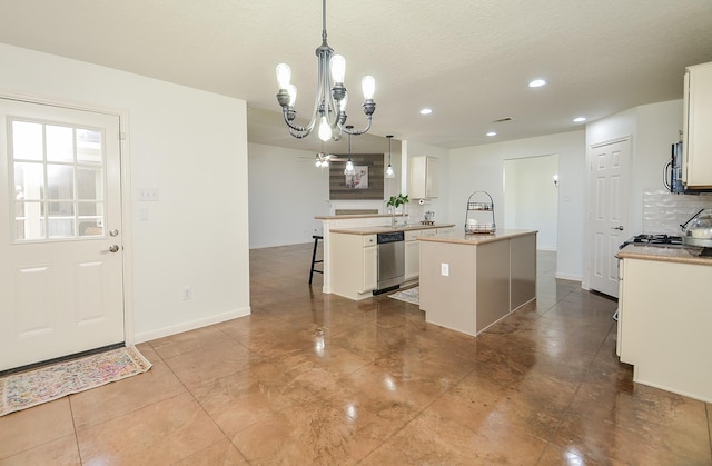 kitchen with a breakfast bar area, a peninsula, white cabinets, stainless steel dishwasher, and tasteful backsplash