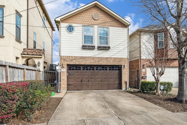 traditional-style home with a garage, brick siding, fence, driveway, and a gate