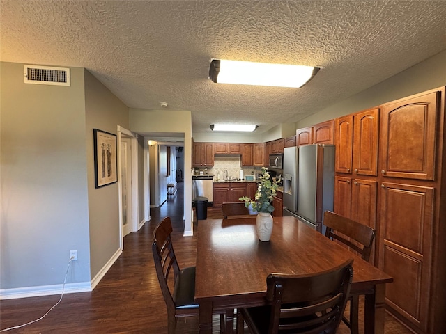 dining space with visible vents, dark wood finished floors, and baseboards