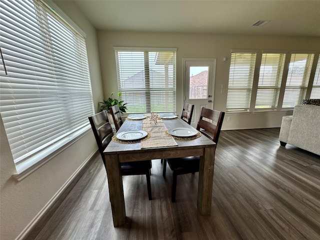 dining space with dark wood-type flooring, visible vents, and baseboards