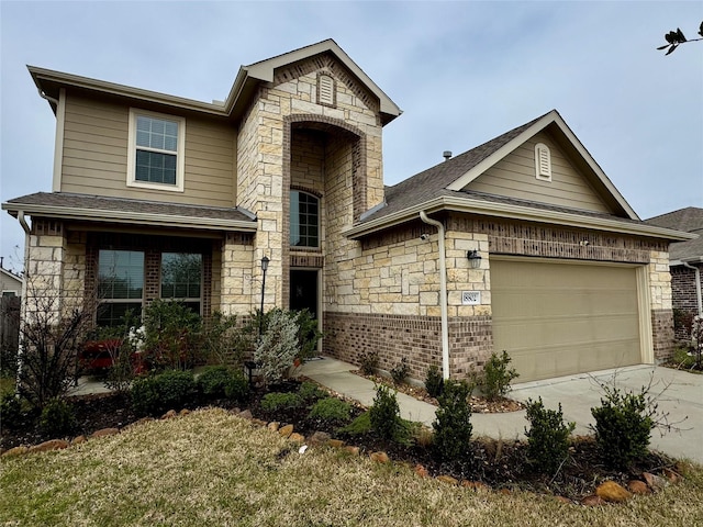 traditional-style home featuring stone siding, a shingled roof, an attached garage, and driveway