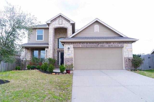 view of front of home featuring a garage, driveway, a front lawn, and fence