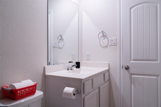 18802 Verdura Dr, New Caney, TX 77357 - half bathroom featuring toilet, a textured wall, and vanity