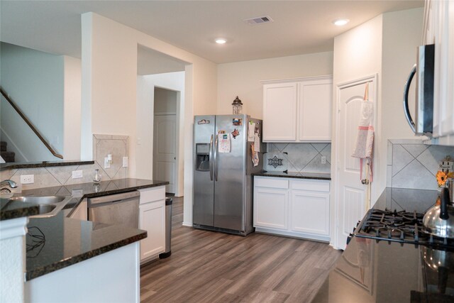 18802 Verdura Dr, New Caney, TX 77357 - kitchen featuring appliances with stainless steel finishes, white cabinets, backsplash, a sink, and visible vents
