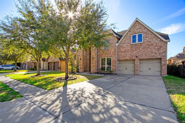 traditional-style house featuring concrete driveway, brick siding, and a front lawn