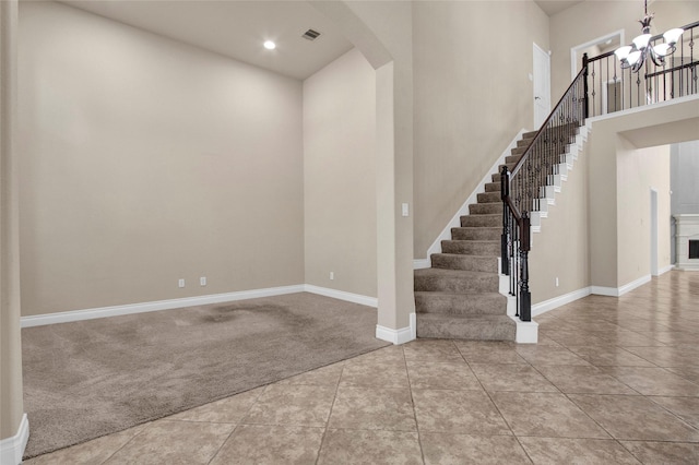 tiled foyer with arched walkways, a notable chandelier, carpet floors, baseboards, and stairs