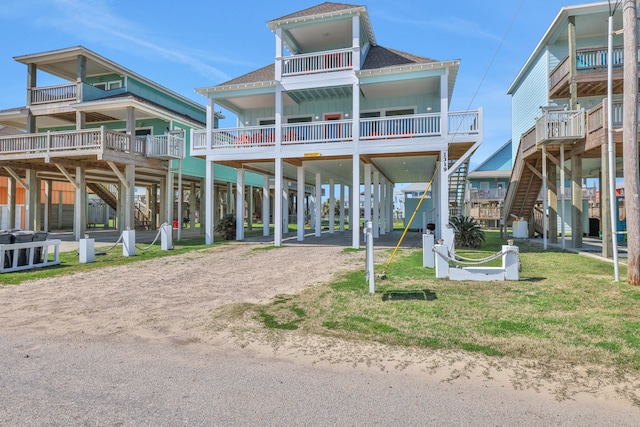 coastal home with dirt driveway, a carport, and roof with shingles