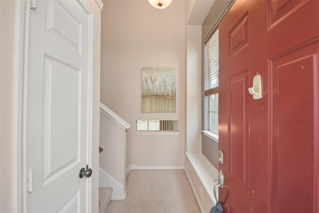 foyer featuring baseboards and stairs