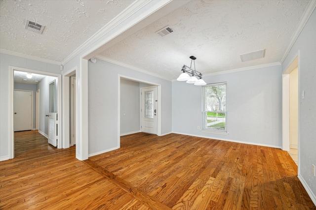 unfurnished room with light wood-type flooring, visible vents, and a textured ceiling