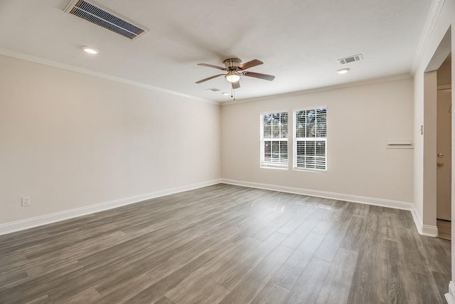 empty room with dark wood-style floors, visible vents, and ornamental molding