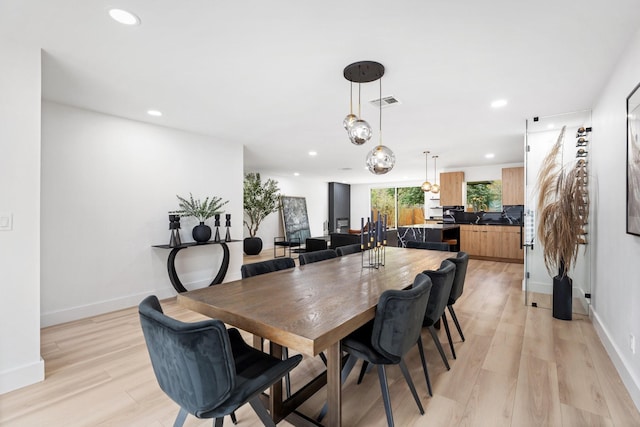 dining room featuring recessed lighting, light wood-style flooring, and baseboards