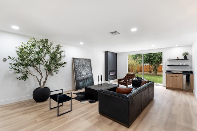 living room featuring recessed lighting, visible vents, light wood-style flooring, and baseboards