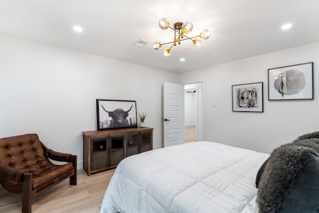 bedroom featuring recessed lighting, visible vents, light wood finished floors, and an inviting chandelier