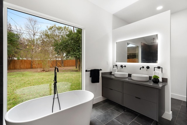 full bath featuring double vanity, a soaking tub, a sink, and tile patterned flooring