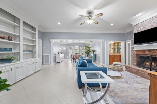 living area featuring a fireplace, light tile patterned floors, visible vents, ornamental molding, and a ceiling fan