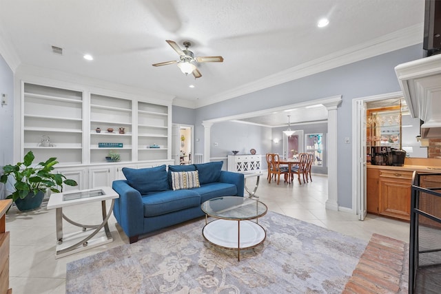 living area featuring crown molding, light tile patterned floors, visible vents, and ornate columns