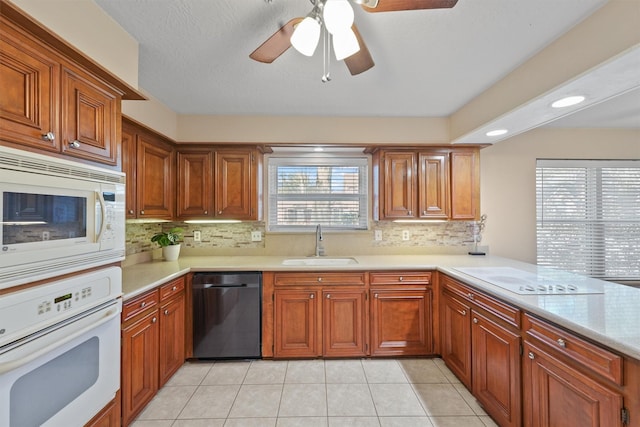 kitchen with white appliances, light countertops, a sink, and light tile patterned flooring